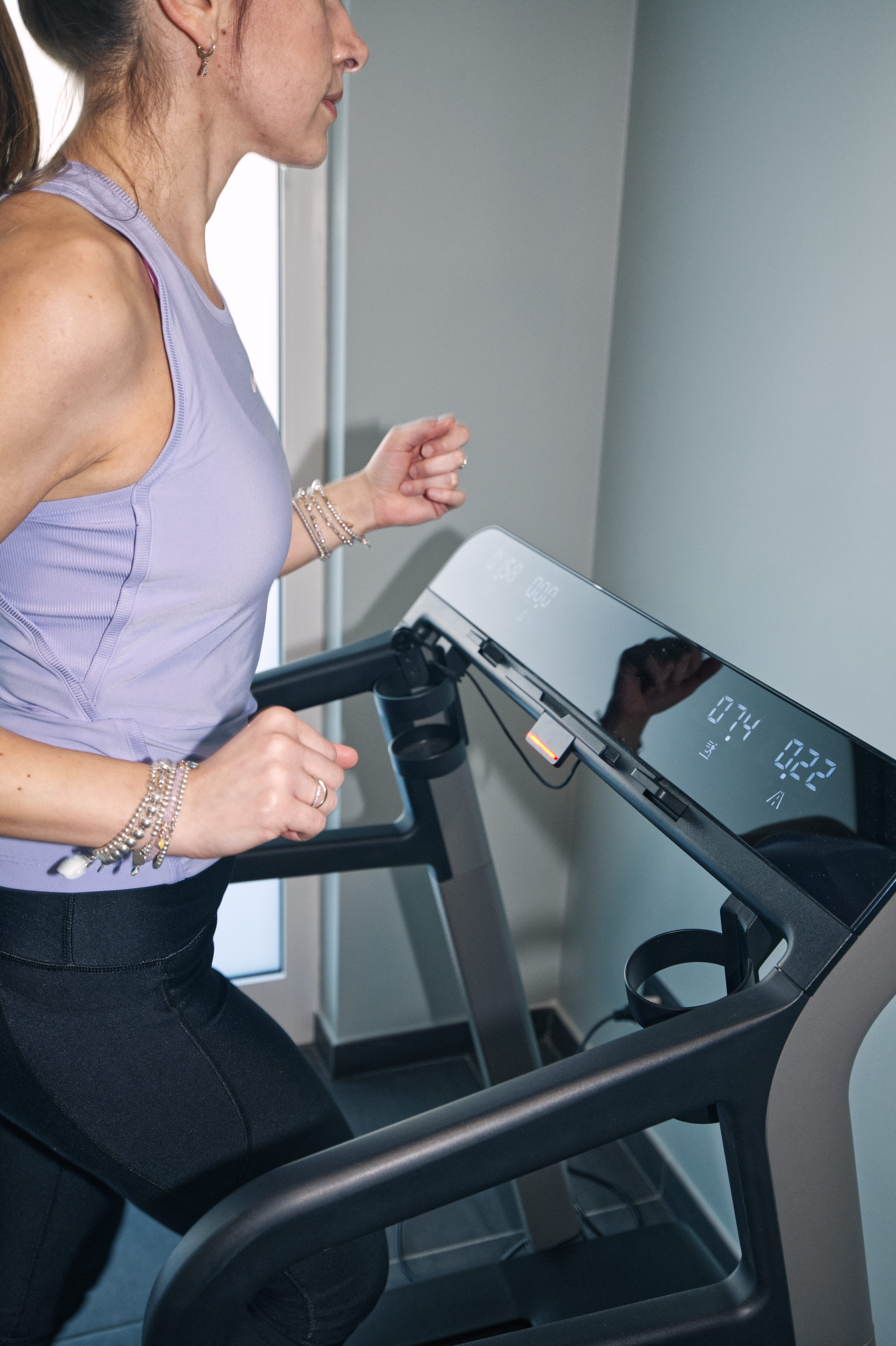 Man with tousled hair sitting at a cluttered desk in a dimly lit room. Warm, orange lighting creates a moody and contemplative atmosphere.