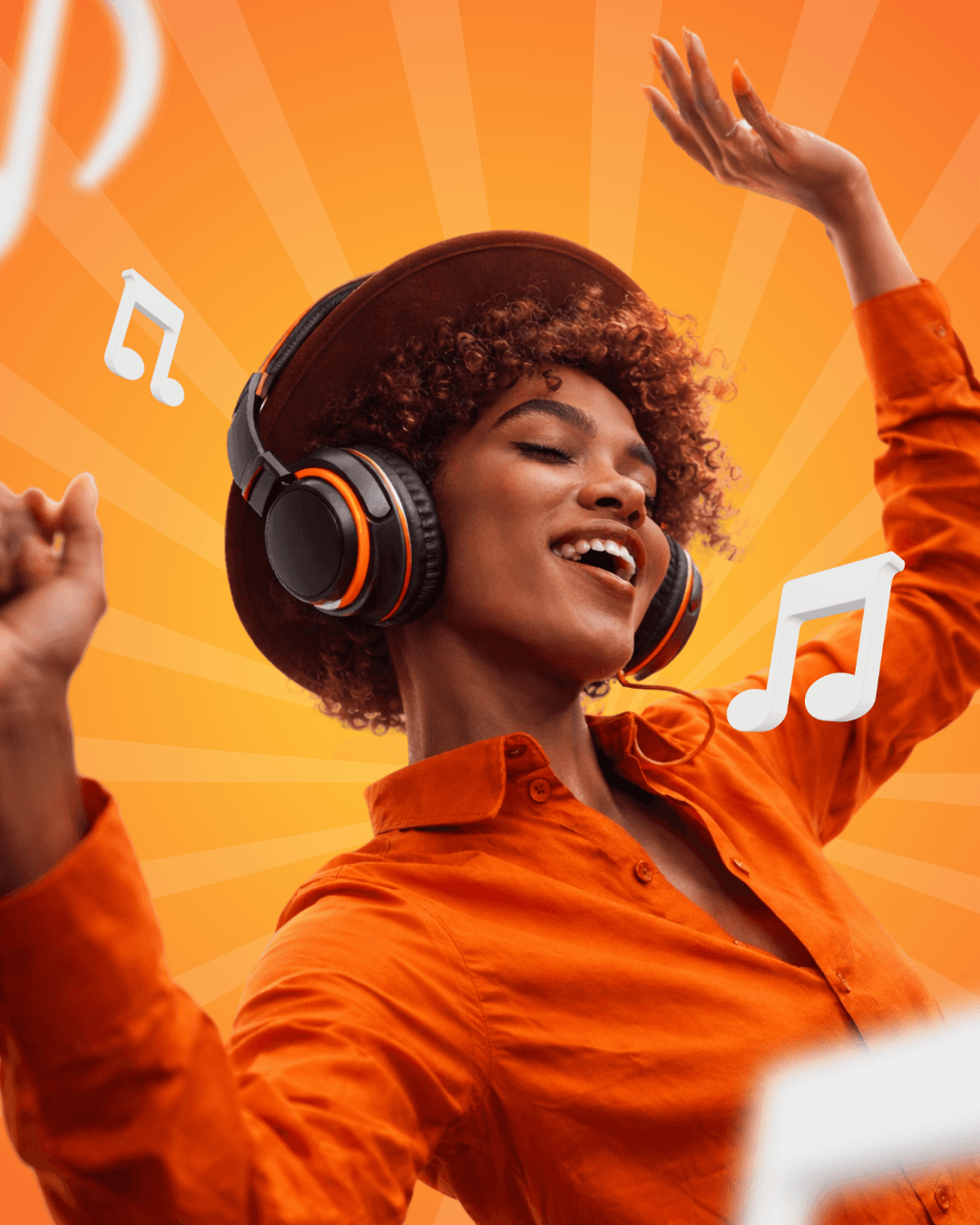 A smiling couple takes a selfie under a clear blue sky. The woman wears a red jacket, and the man, in a green top, holds a smartphone.