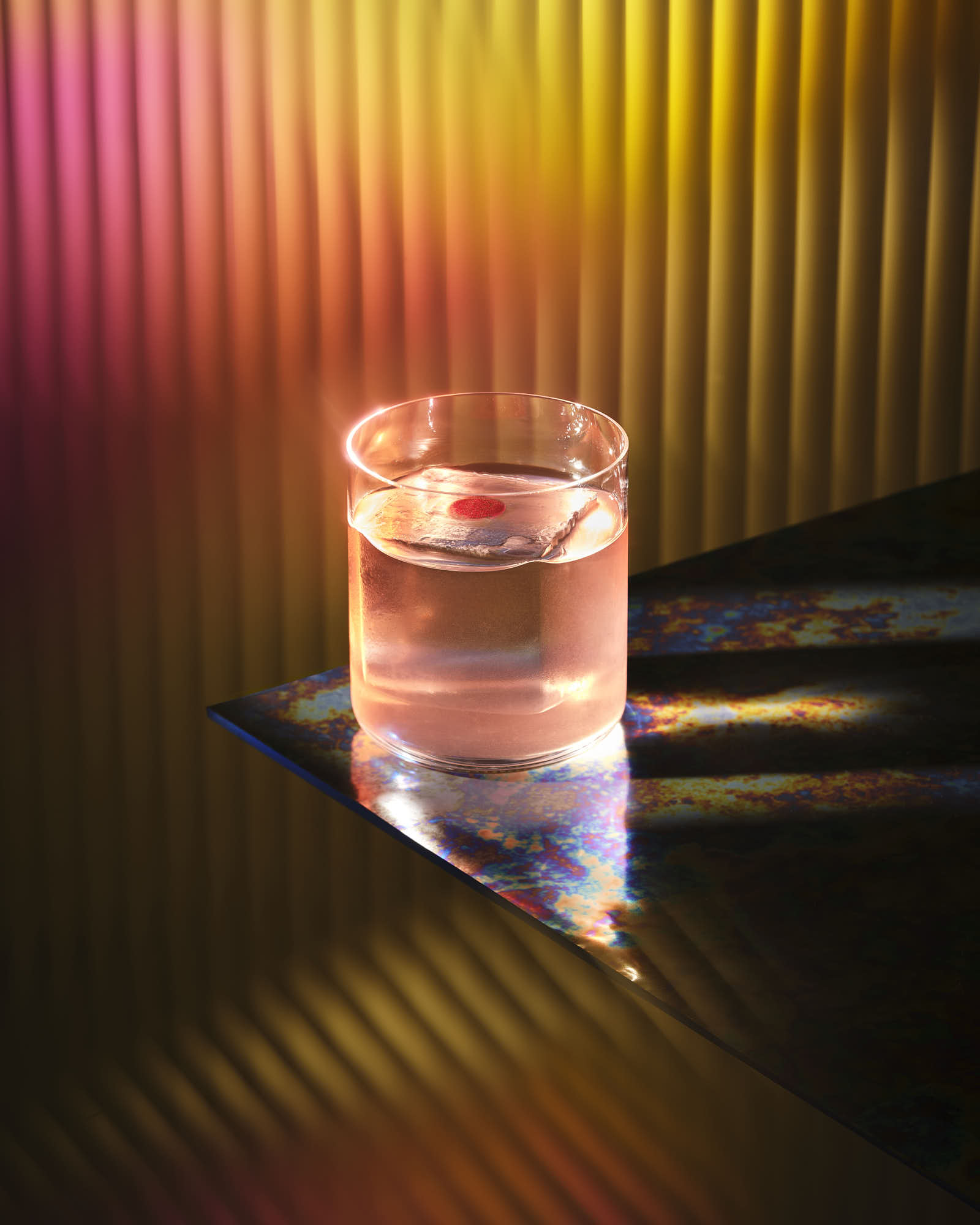 A clear glass filled with water sits on a reflective surface, surrounded by colorful, gradient lighting.