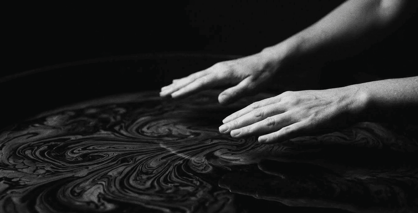 hands floating over dark water