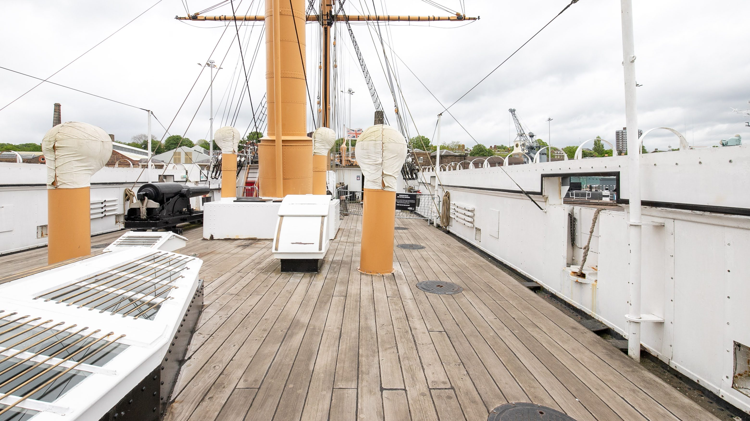 Two classic volkswagen beetles, one green, one cream.