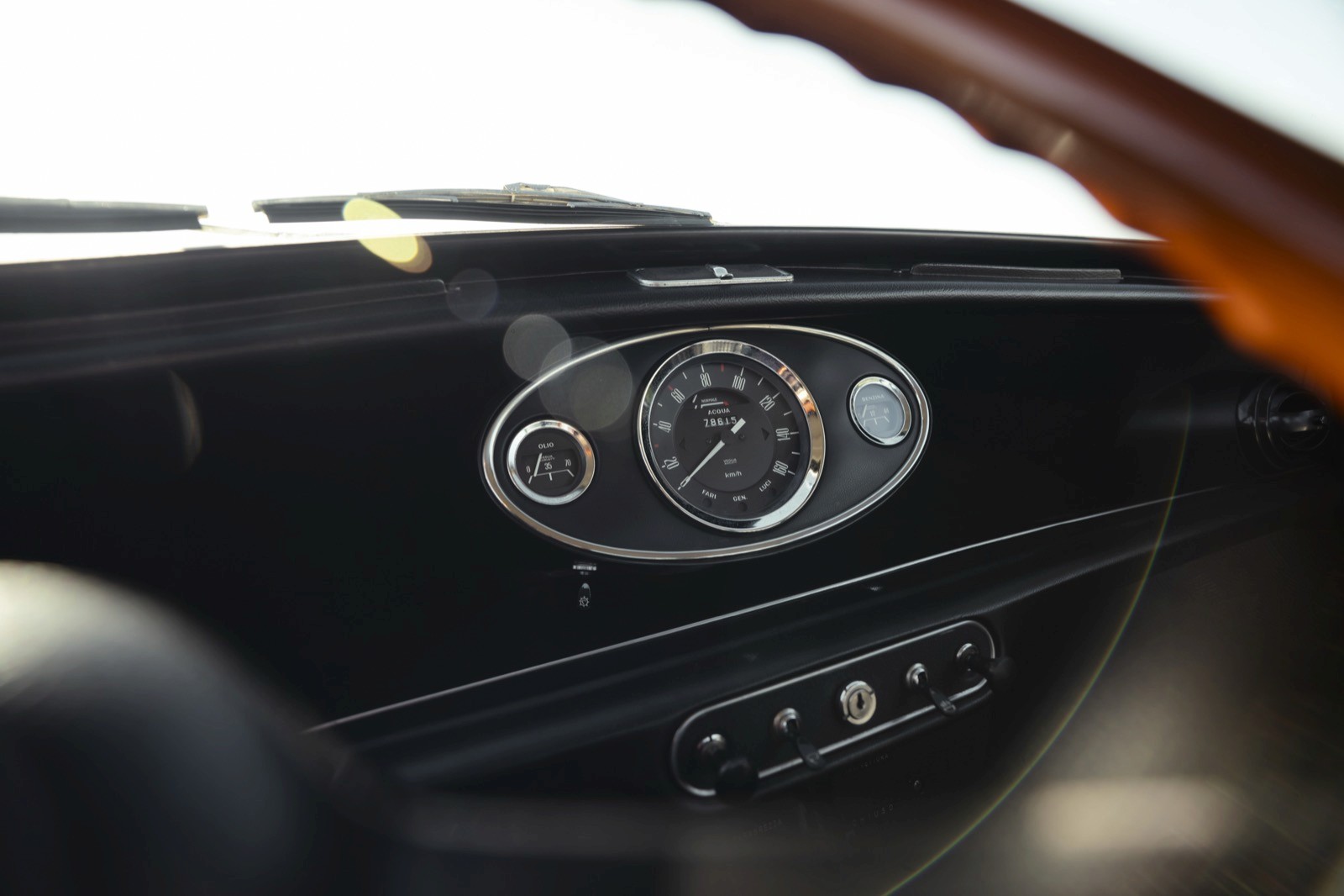 Close-up of a car's dashboard featuring a round analog clock and air vents in a sleek design.