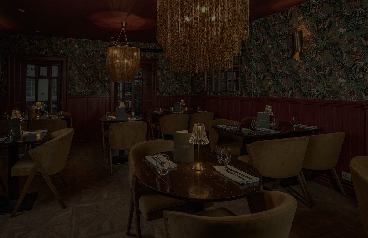 Dimly lit room with sunlight filtering through curtains, casting shadows on a green marble table with a single plate of pasta in the center.