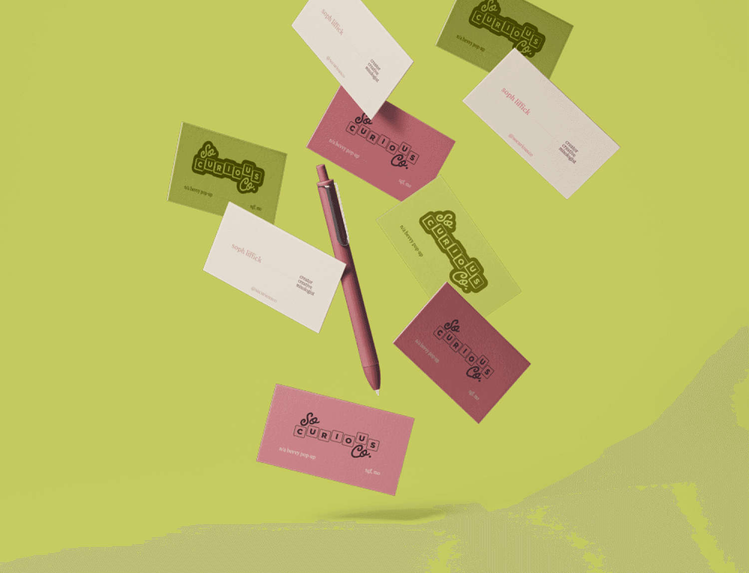 Business cards for So Curious Co falling on a lime background