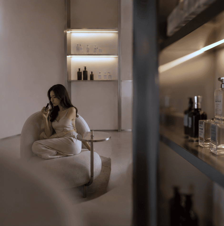Client seated in a quiet clinic lounge beside product shelving