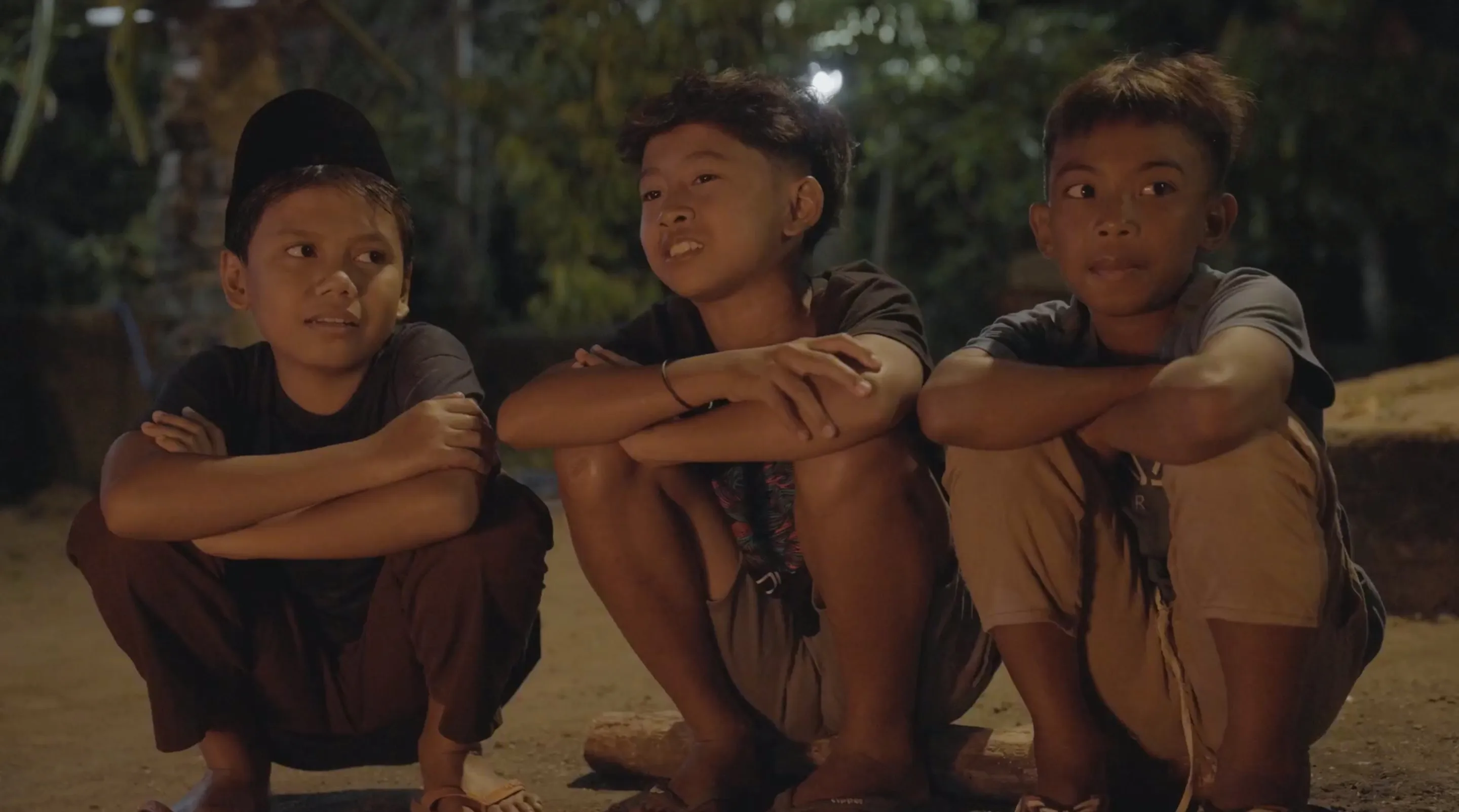 Children from the village of Genggelang in Lombok, Indonesia, sitting by a bonfire