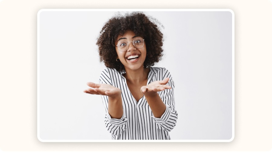 Jeune femme souriante aux cheveux bouclés, lunettes, mains ouvertes,