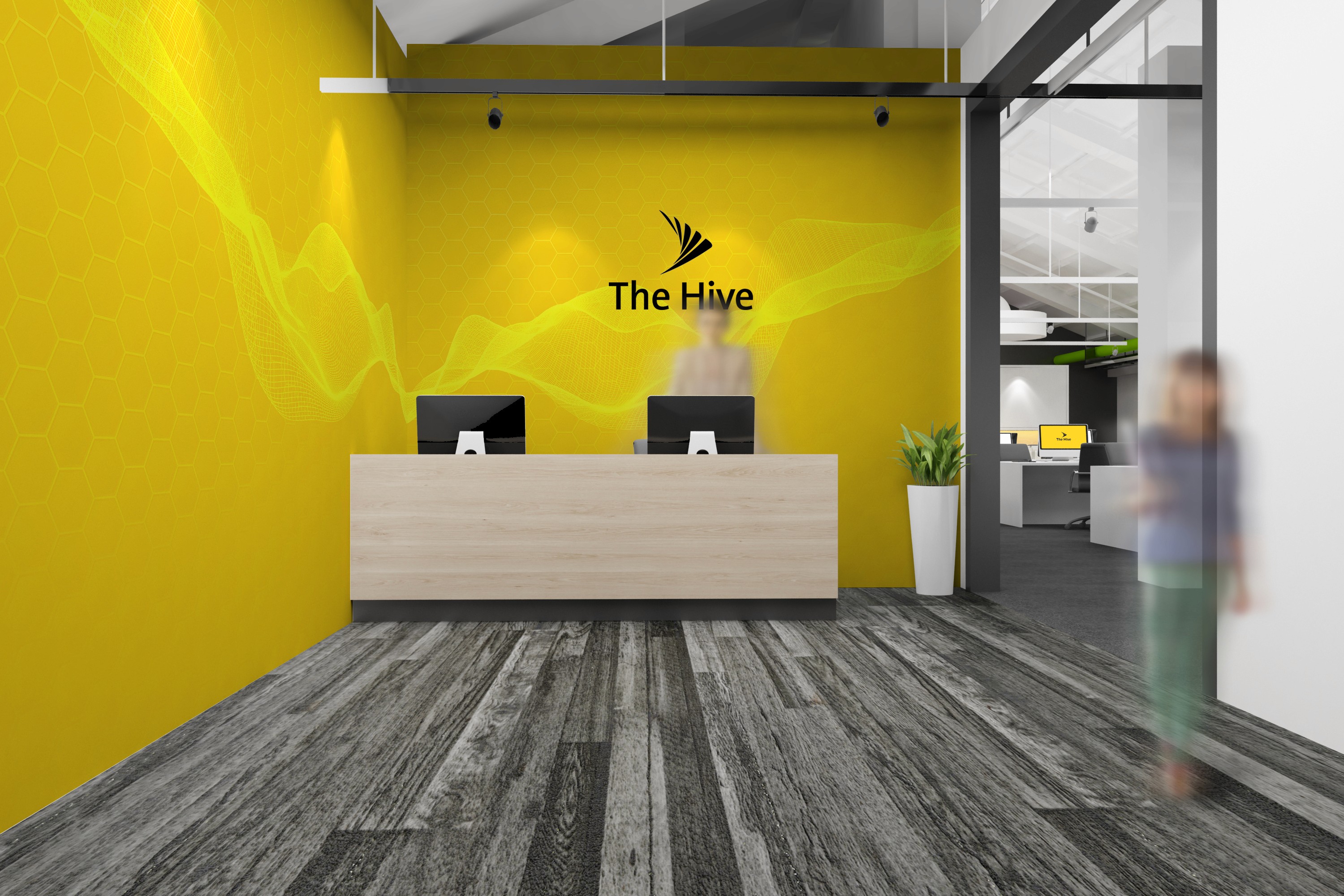 The Hive office reception with a yellow wall, honeycomb-pattern light streaks and a wooden front desk