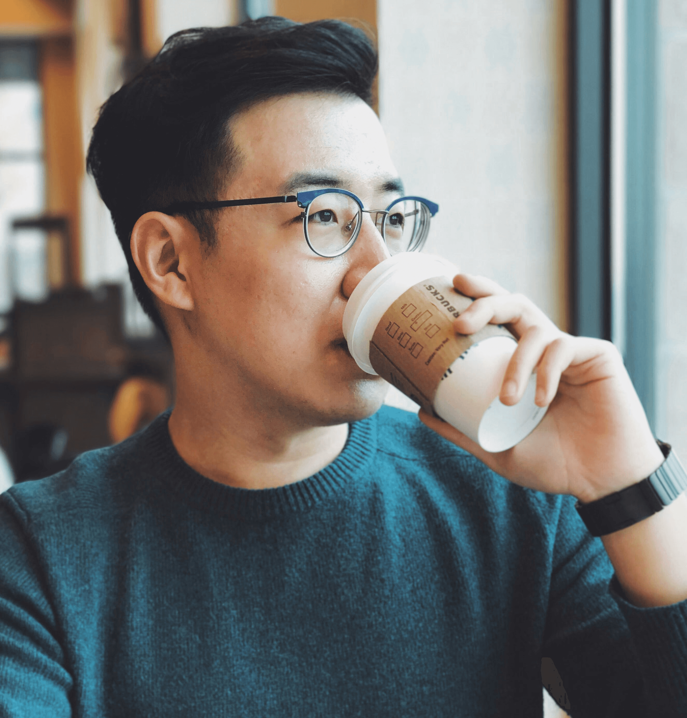 man holding Starbucks disposable cup