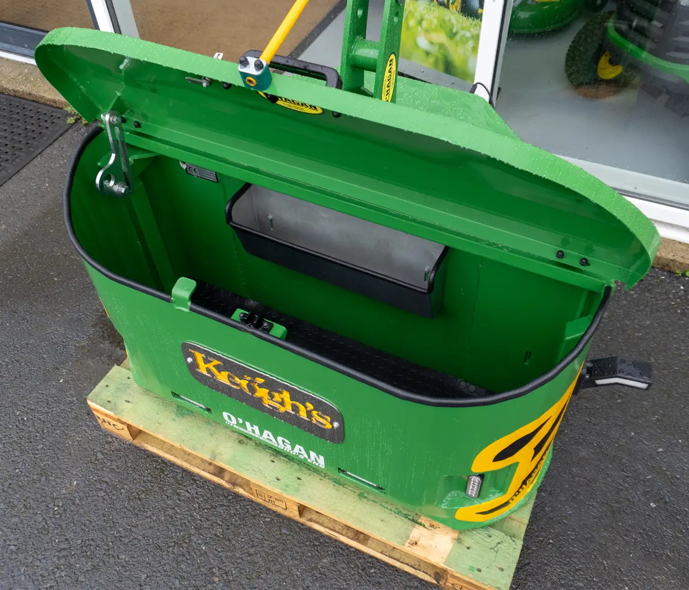 inside of opened Green and yellow Work box with a yellow and black custom name plate sitting on a pallet inside on a carpet