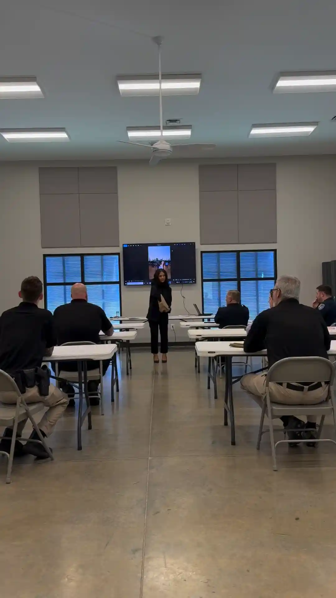 Alejandra presenting a case review to police officers in a training room
