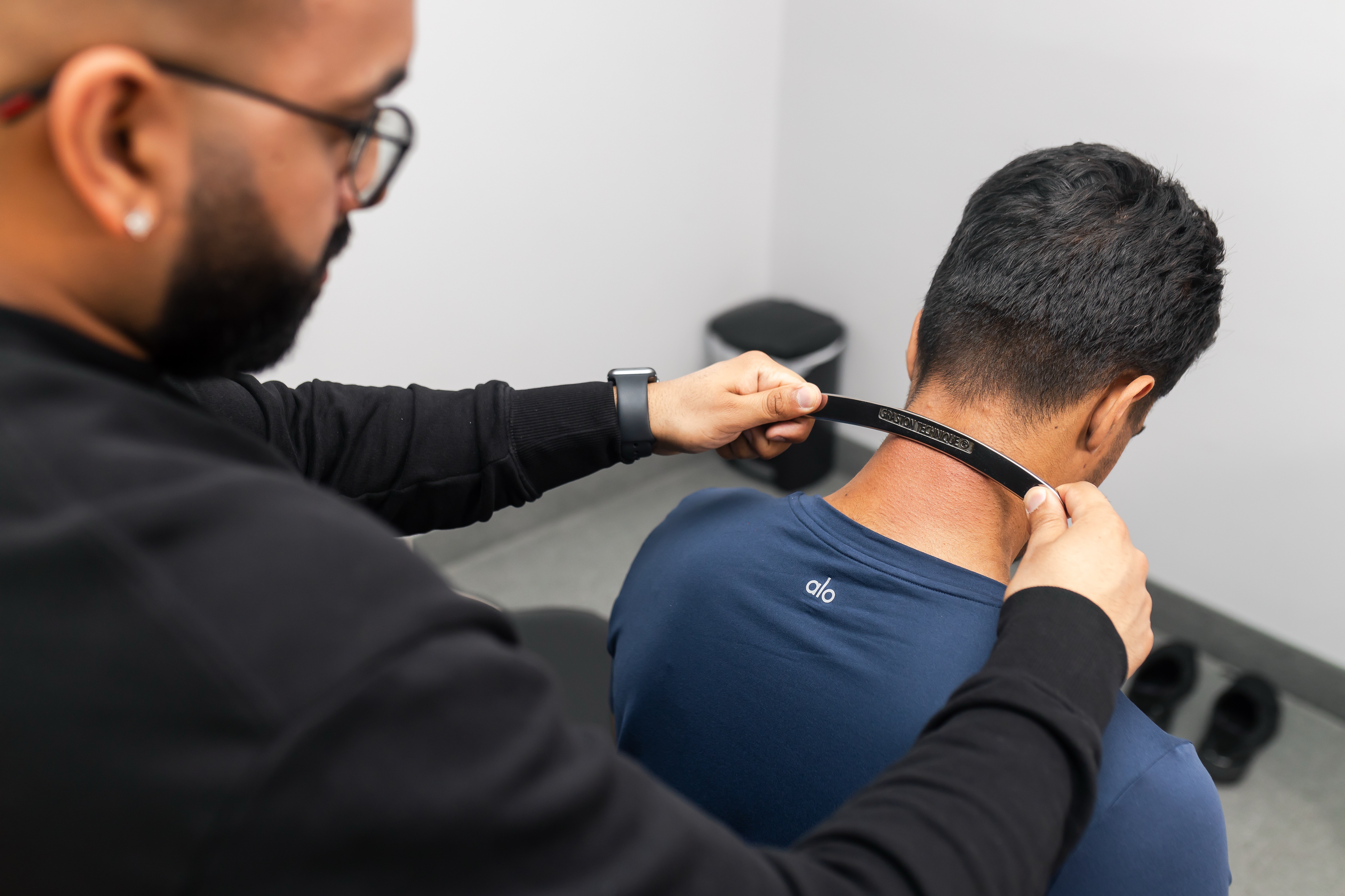 physiotherapist performing Graston Technique on patient’s back