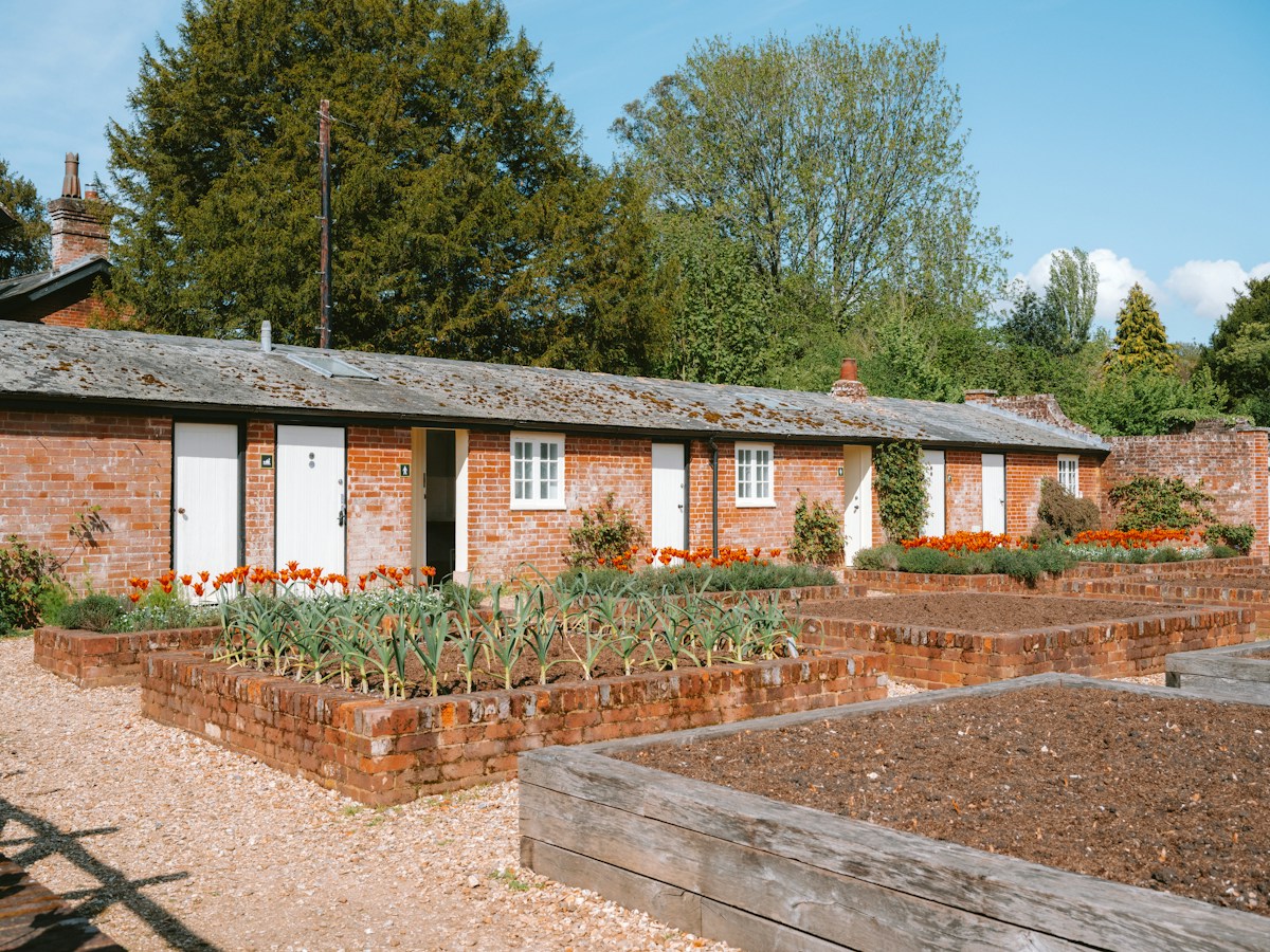 A low brick building behind raised vegetable beds
