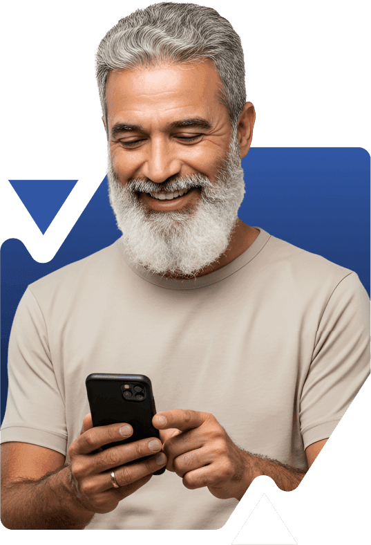 Um homem mais velho sorridente, com barba grisalha, olha para seu smartphone, parecendo feliz e engajado.