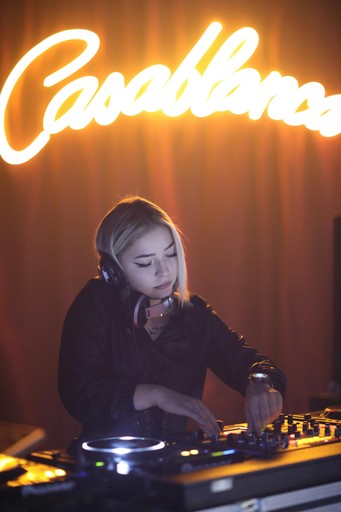 Minimalist abstract image of a stylized turquoise hand gesture on a dark background