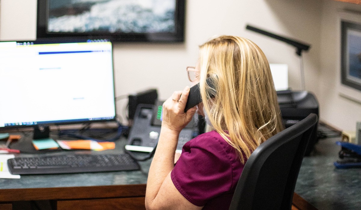 A happy CSR on the phone in their office
