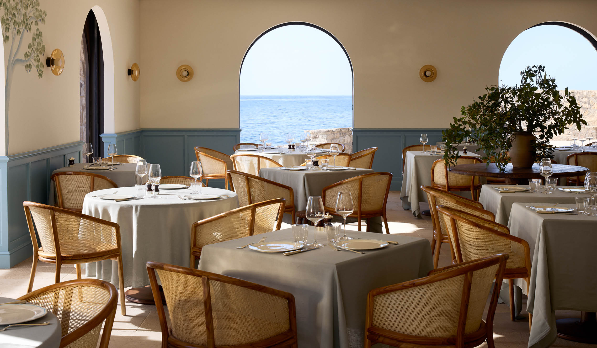Le Grand Large dining room on Île de Bendor, white tablecloths and arched windows onto the sea