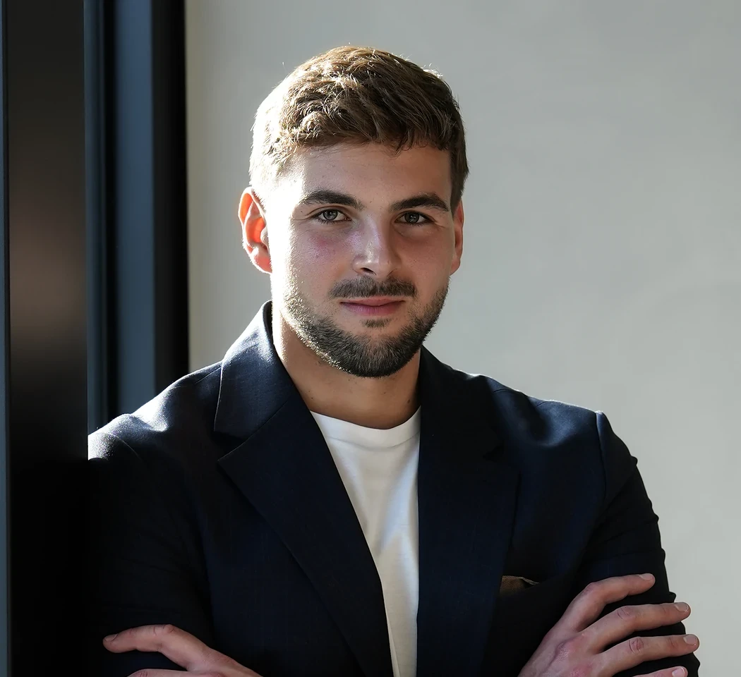 Jan Raška s úsměvem, ruce založené