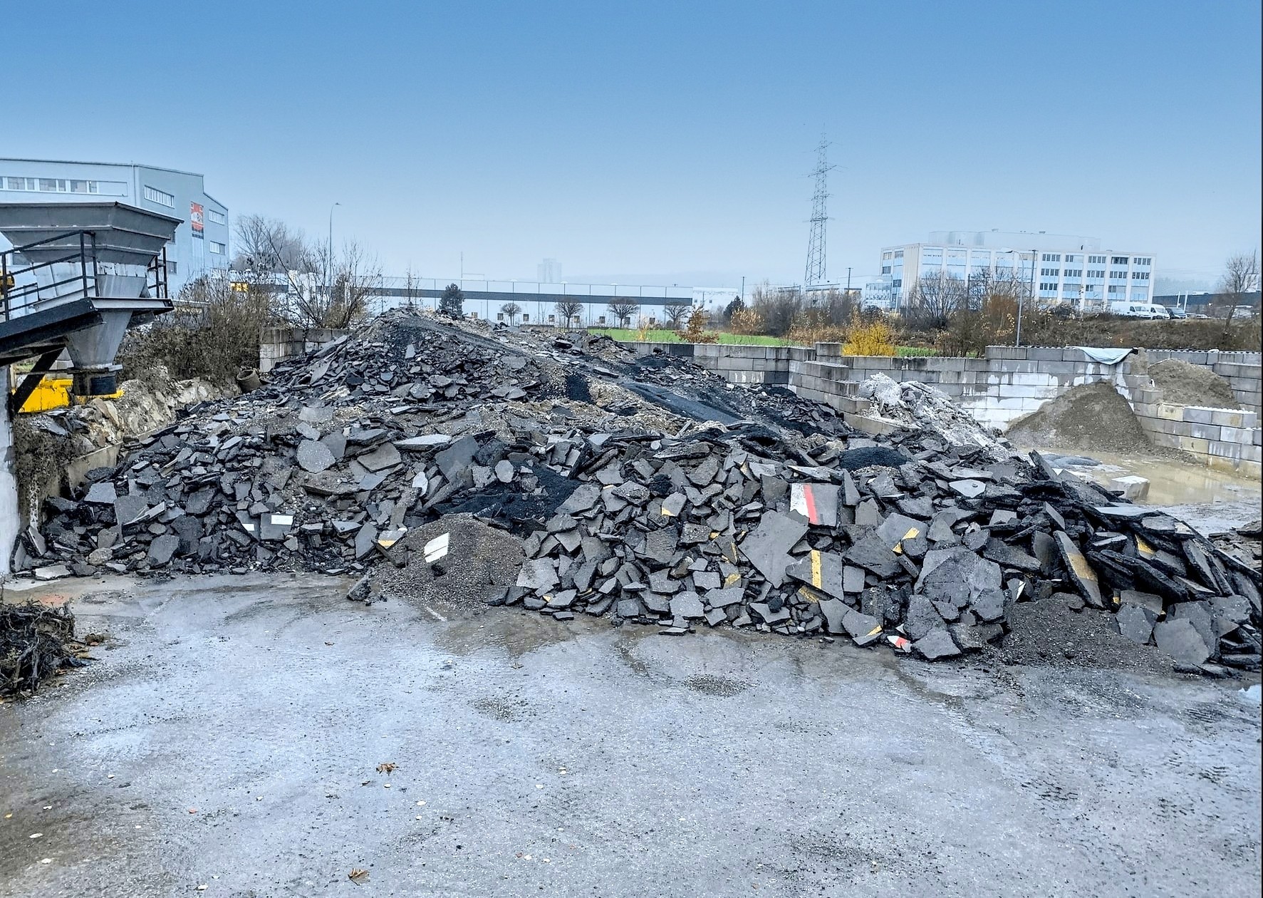 Pile of recycled asphalt and construction debris at Strub Bau AG site – material reuse and sustainable waste management in civil engineering.