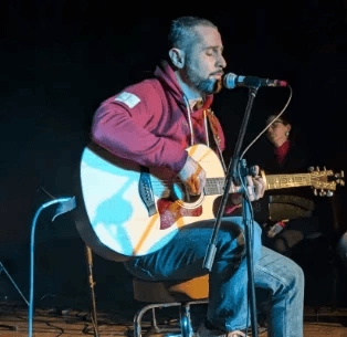 Performer under spotlight on dark stage