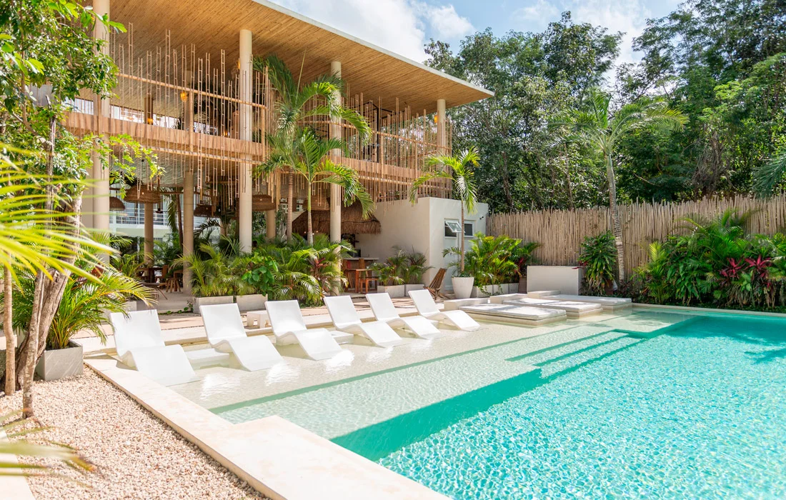Acceso de Kaah Tulum entre palmas y selva, vivienda de barrio