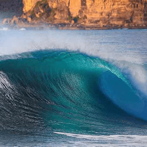 A large, turquoise wave crashing against shore – surfboard rental in central-coast