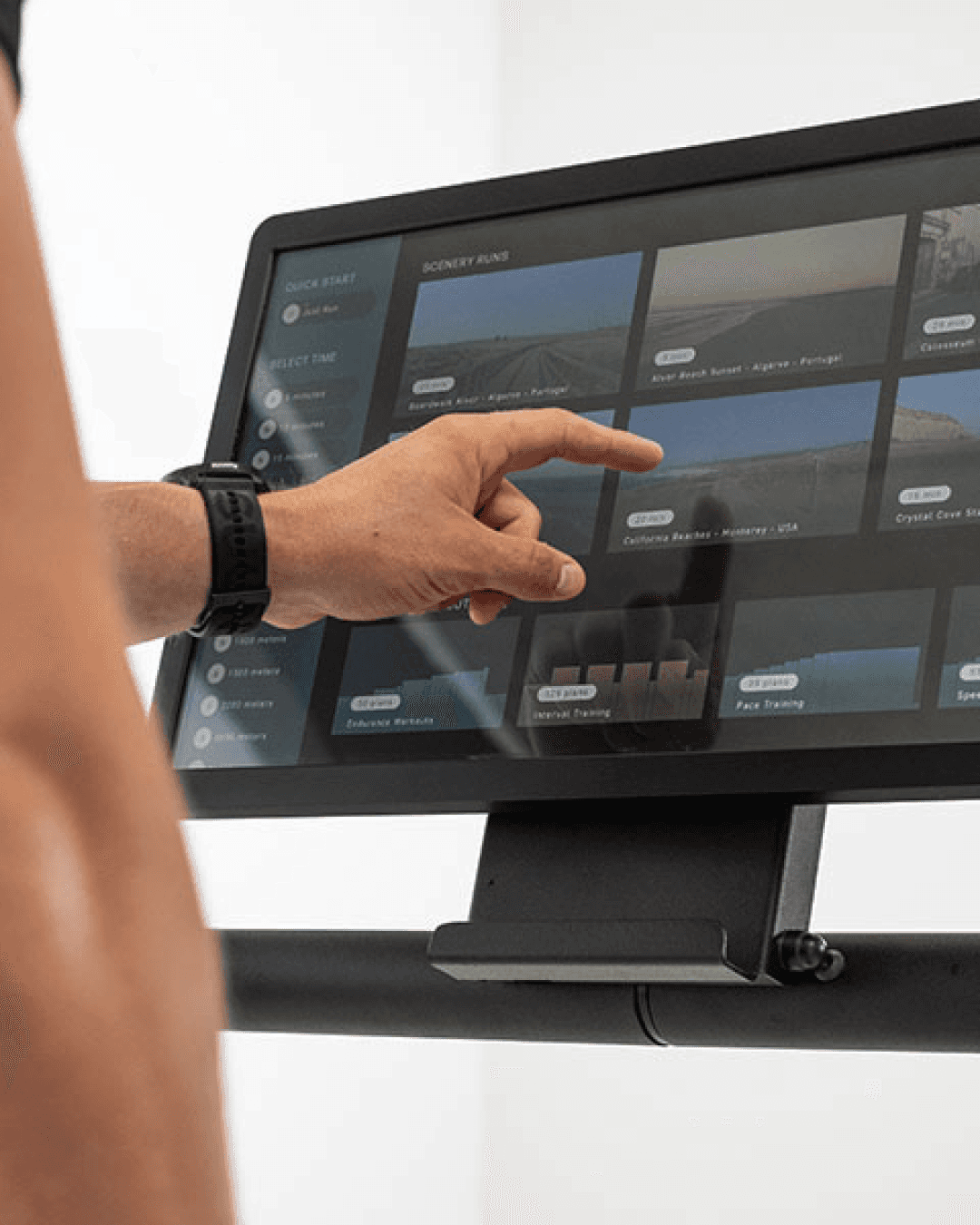 A tablet mounted on a running tredmill that displays many different scenery options for the workout