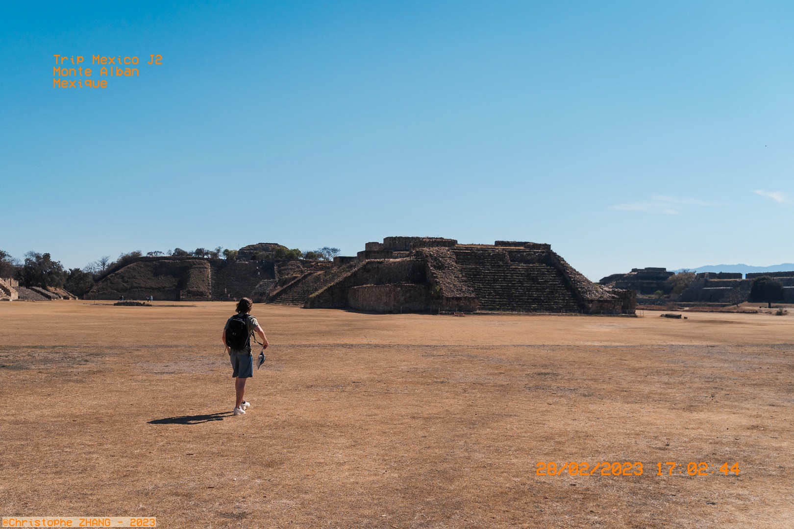 Homme marchant seul vers les pyramides antiques de Monte Albán.