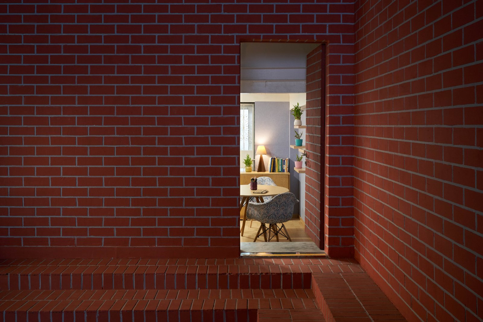 Red brick terrace passage creating transition between indoor learning spaces.