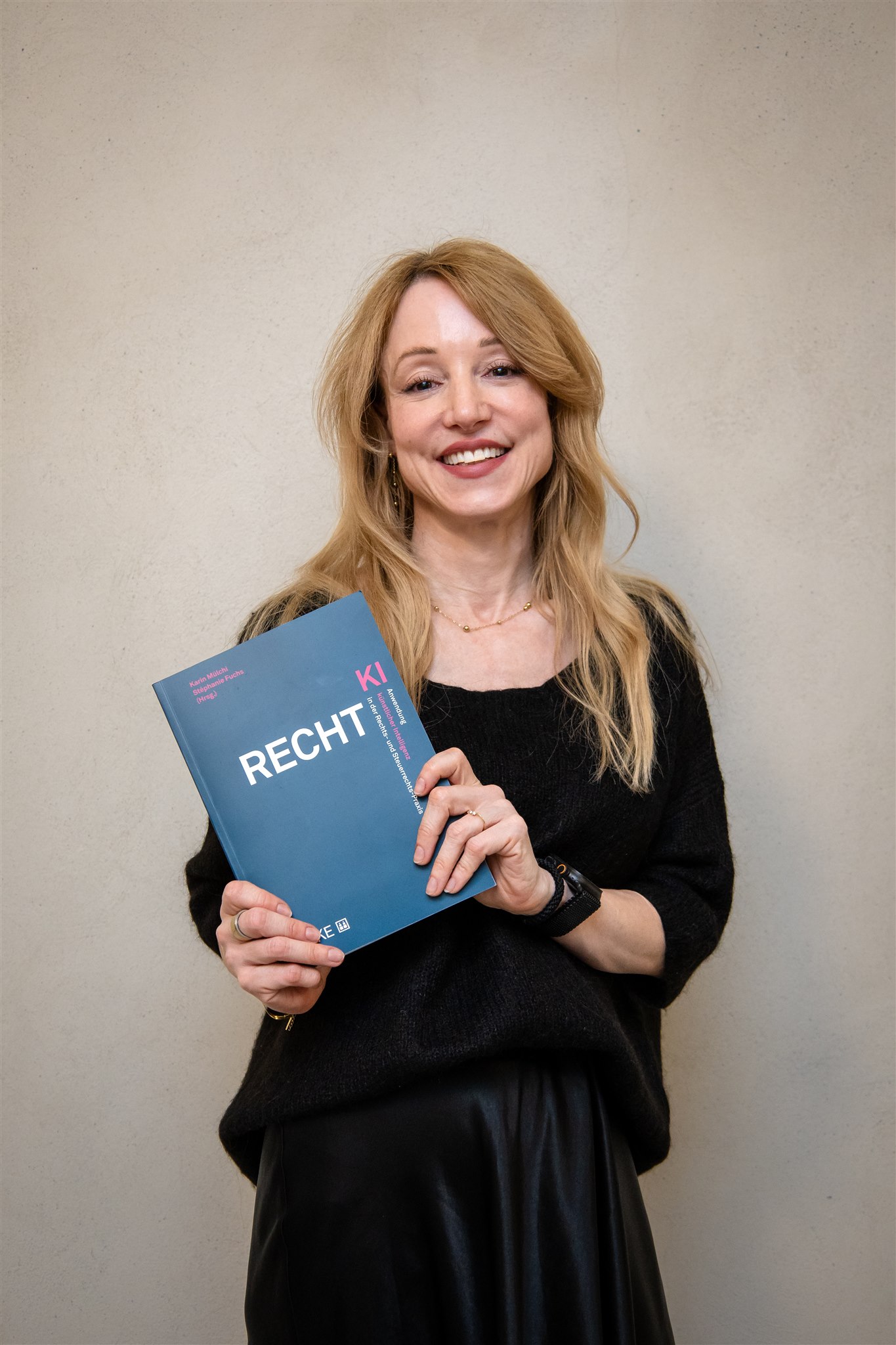 Author holding the Recht KI book at book launch event in Zurich