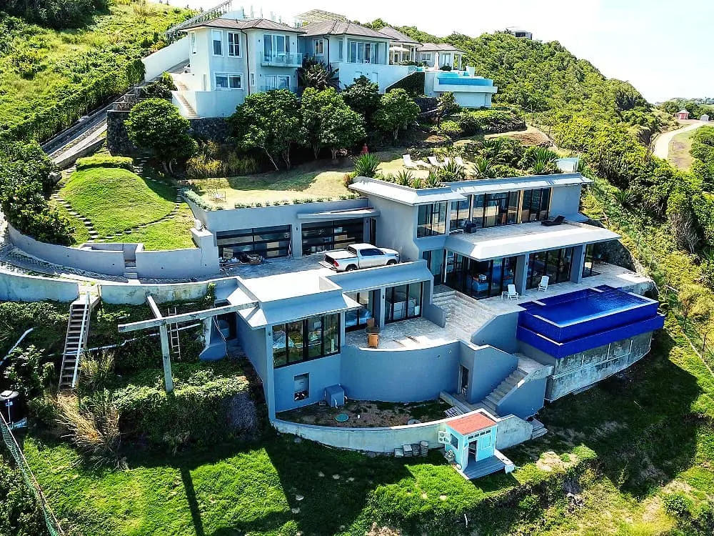Aerial view of completed multi-level clifftop residence with infinity pool and ocean views, St. Lucia