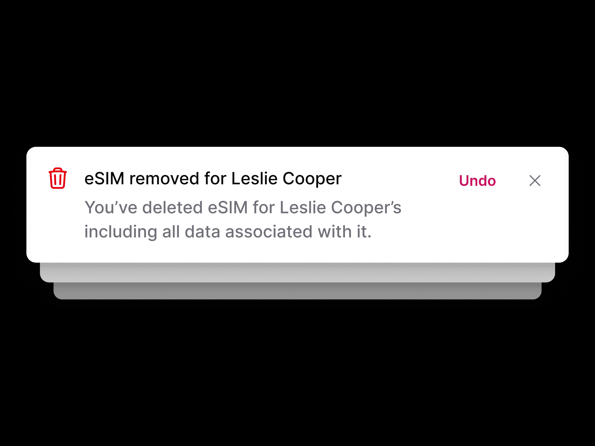 На черном фоне отображается уведомление «eSIM удалена для Лесли Купер» с вариантами действий «Отменить» или «Закрыть». Это означает, что данные были удалены.
