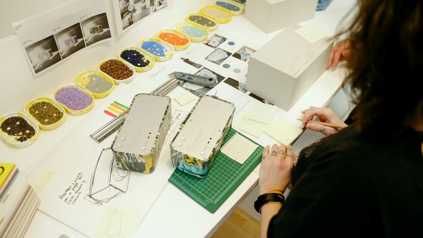 Designer assembling packaging prototypes at a workshop table