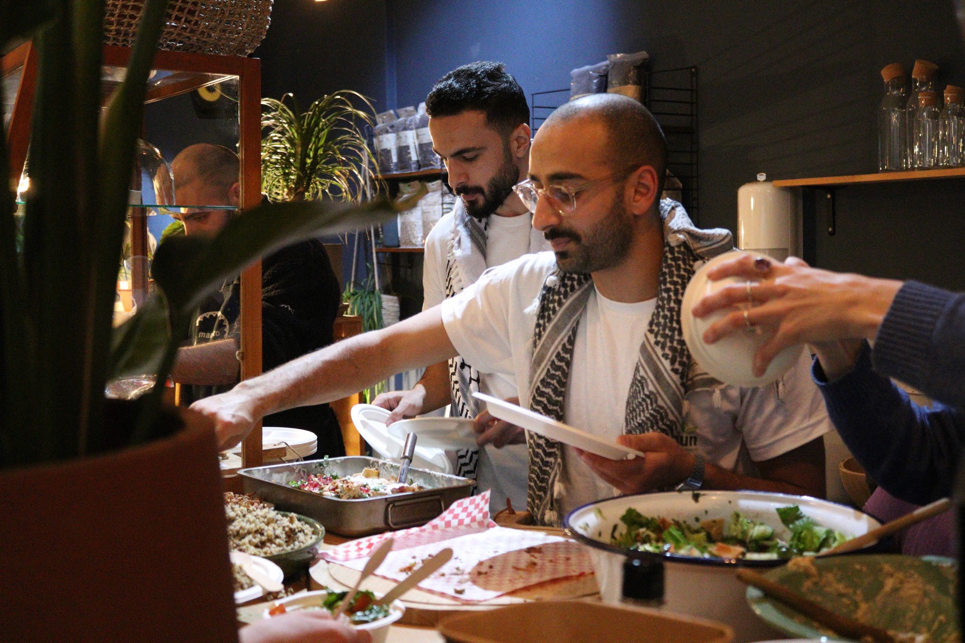 two men serving food at an event