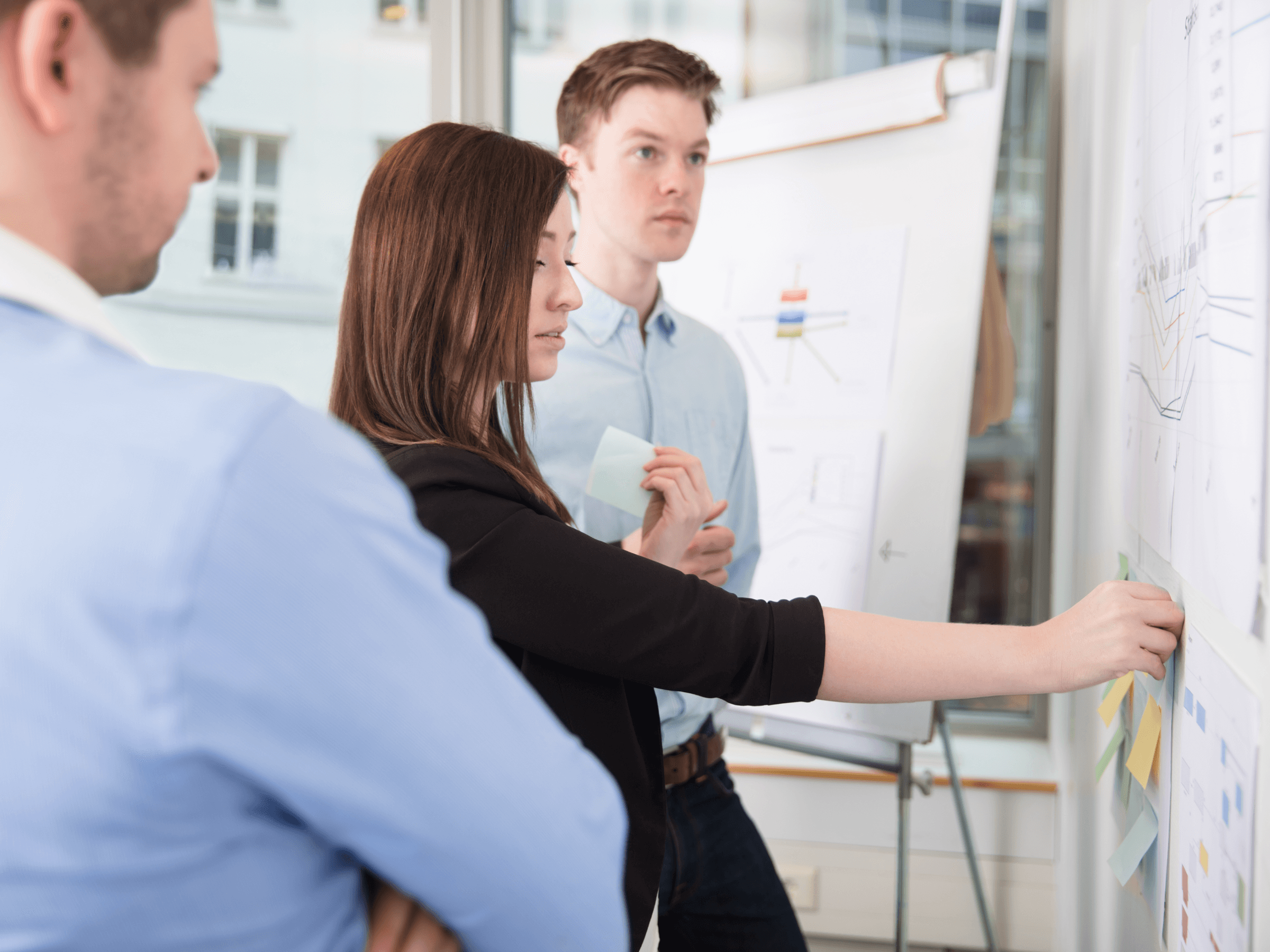 Team conducting a card sorting exercise on a whiteboard as part of information architecture development, with categorised sticky notes and collaborative discussion.