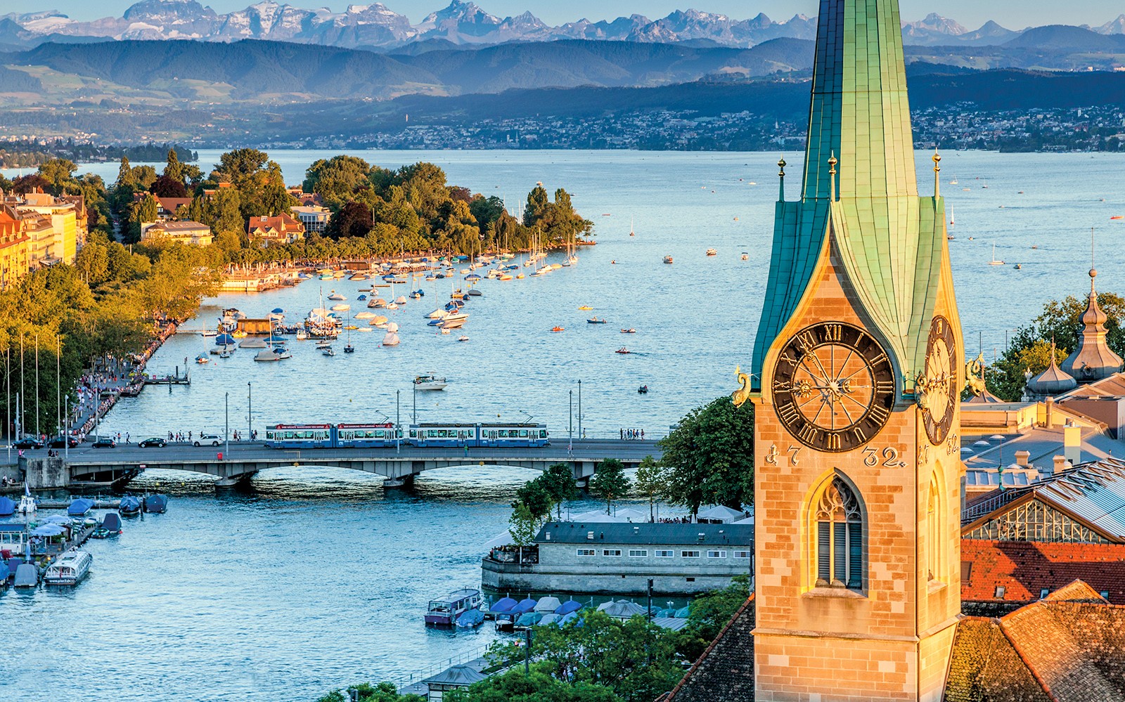 취리히 도시 풍경: 취리히 호수, 보트, 그리고 역사적인 시계탑.