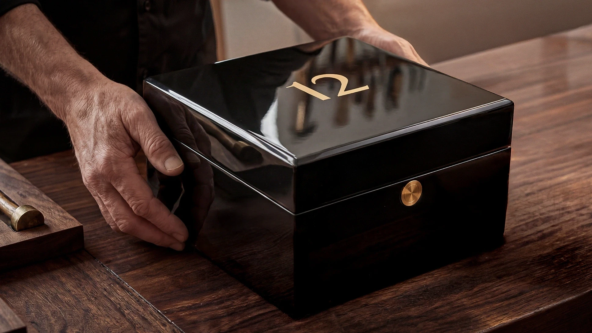 Boxmaker placing a polished black presentation box for a 12 commission