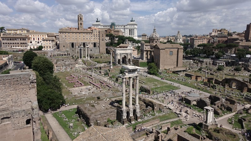 A photo with a view to a park and some roman temple ruins.