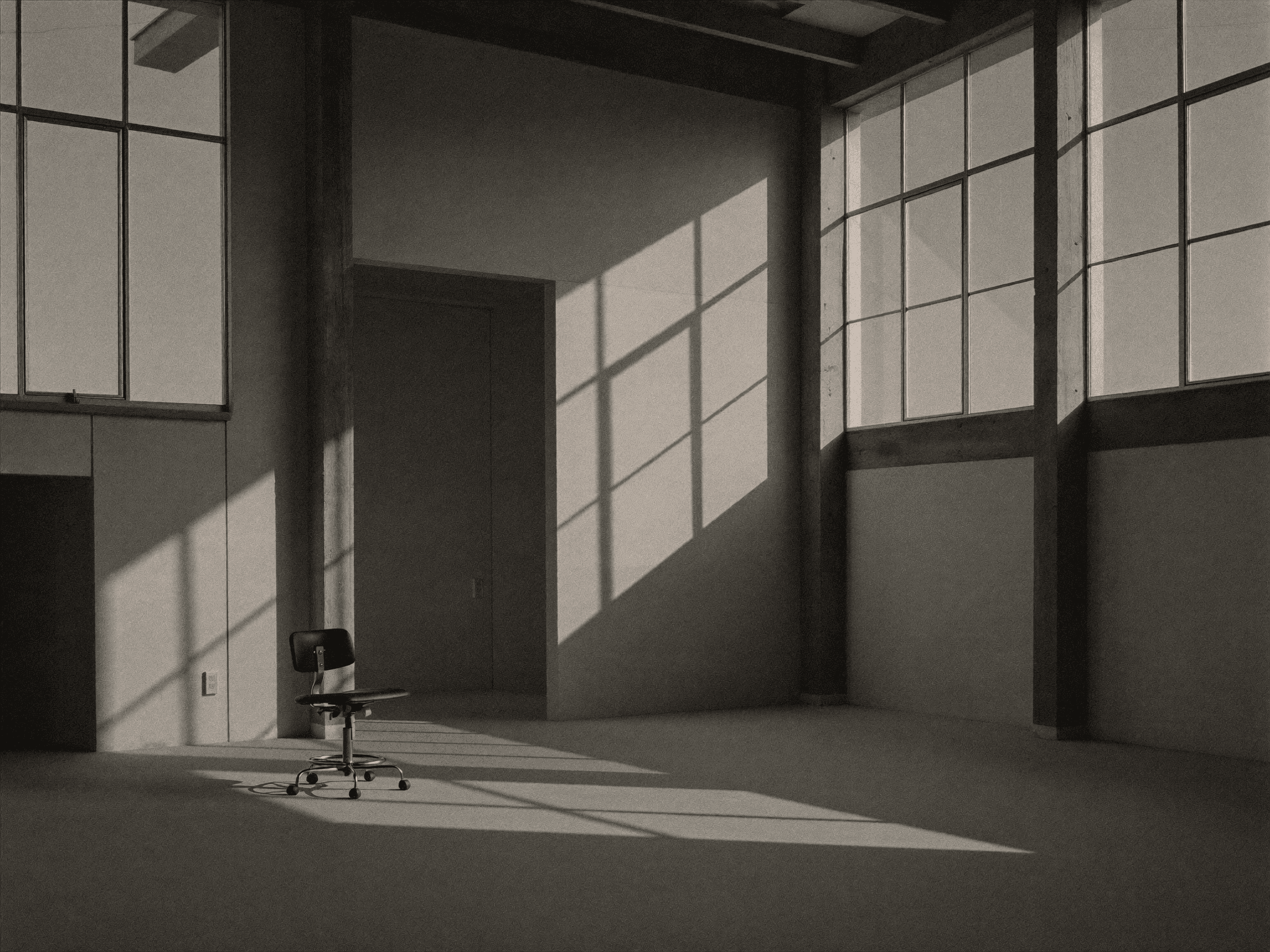 Minimal concrete and timber studio space in late light