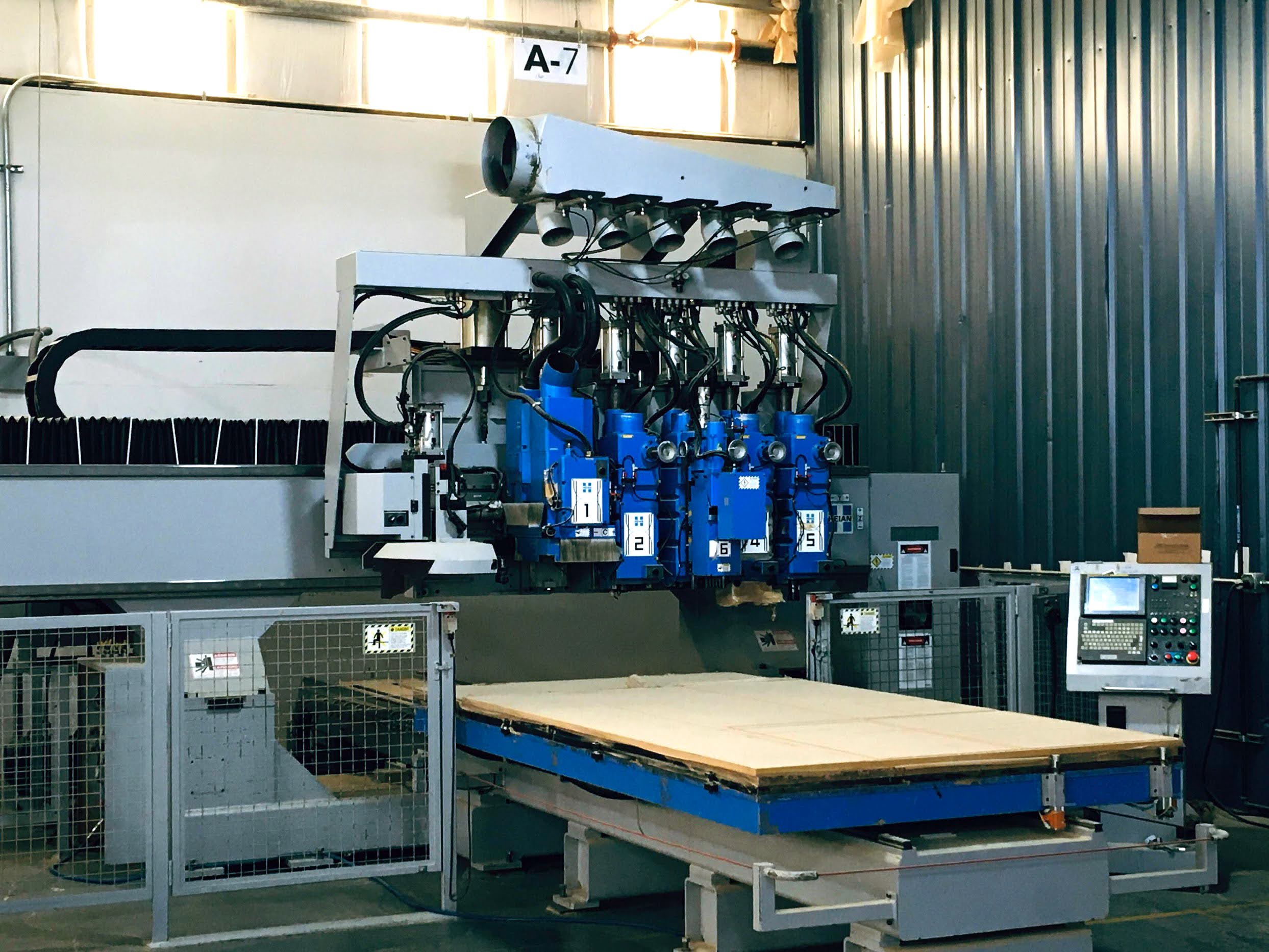 Modern red brick apartment or office building viewed from below against a blue sky, showcasing its geometric architecture with evenly spaced windows and balconies.