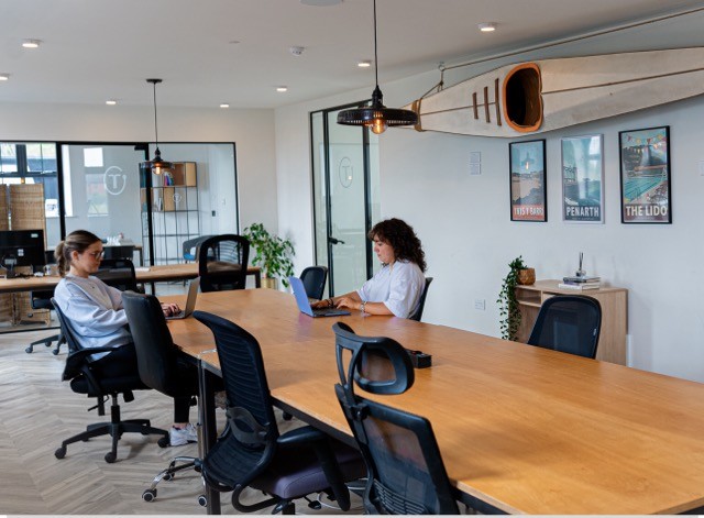 People working at desks in a large office.