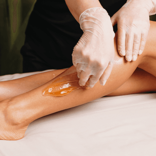 A woman getting her legs waxed at a spa salon