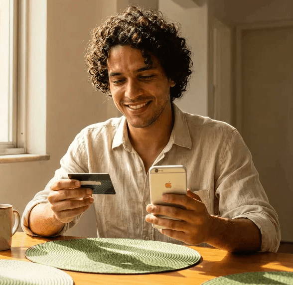 Homem com um celular e um cartão de crédito na mão