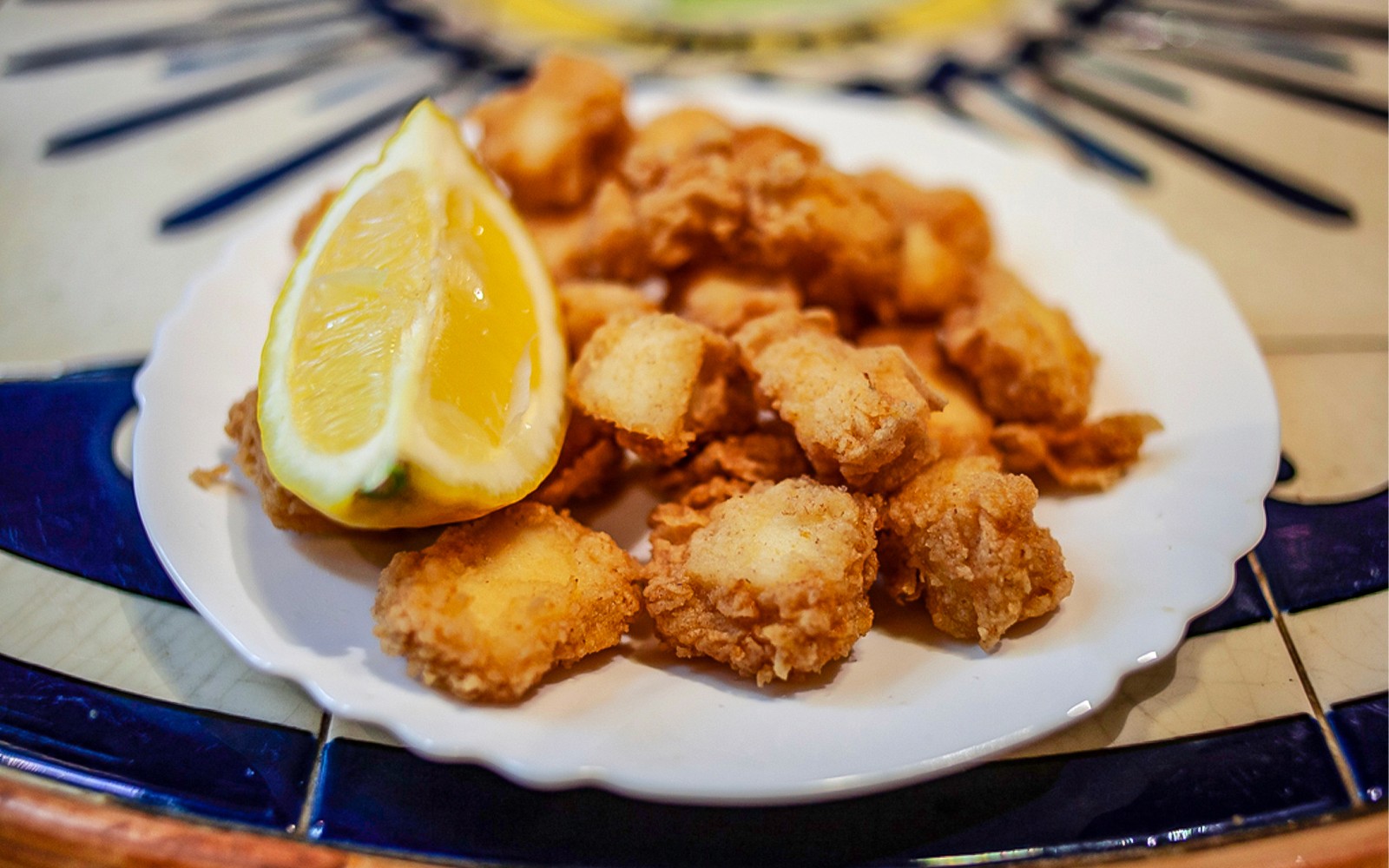 Sült tengeri herkentyűk citrommal egy tányéron a La Barceloneta ételtúra során.