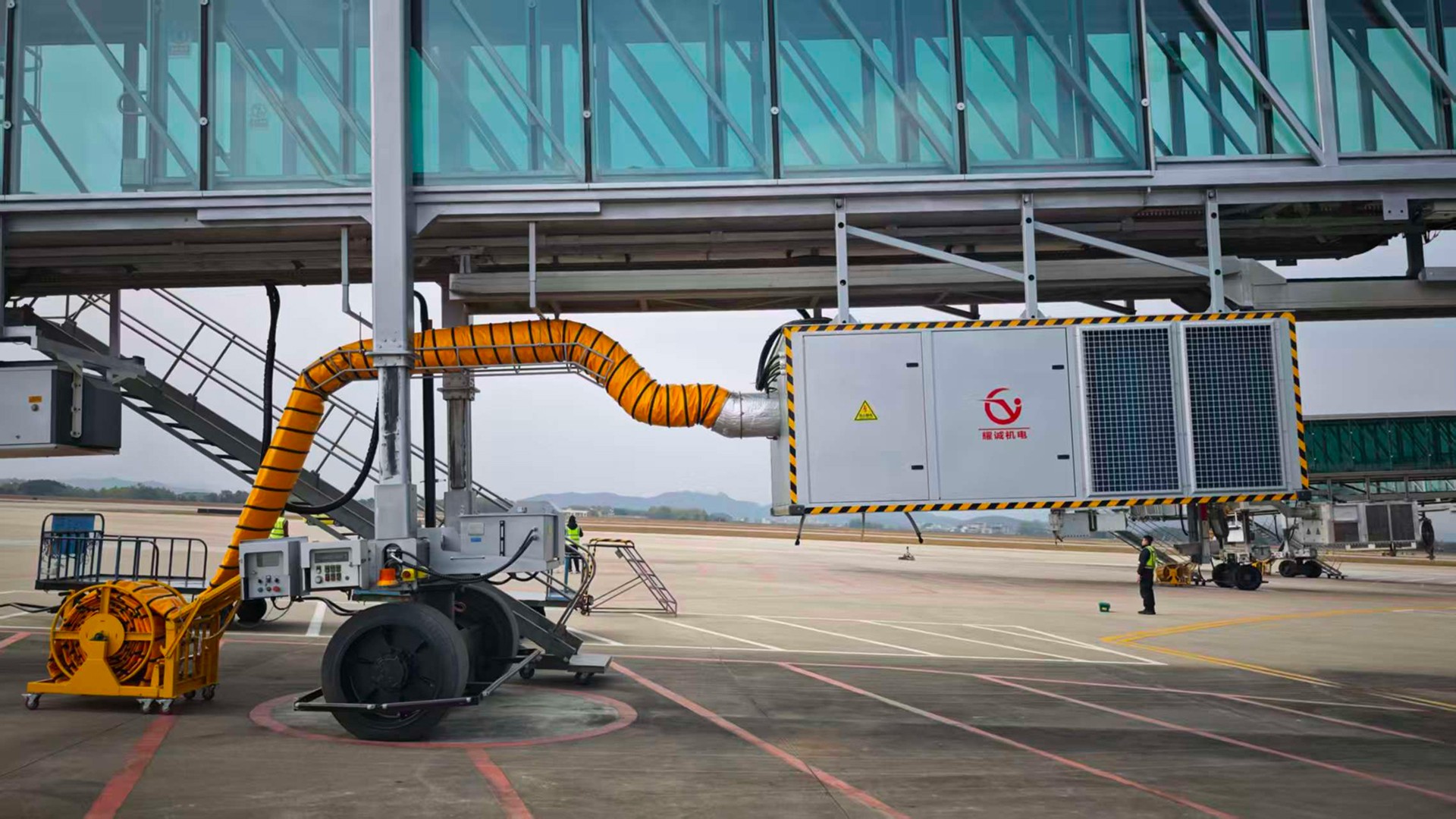 Bridge-mounted YCair pre-conditioned air unit operating beneath an airport passenger boarding bridge.