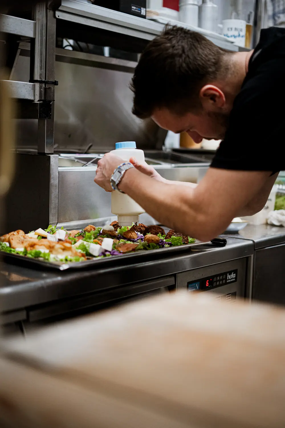 Koch richtet frische Gerichte professionell in Restaurantküche an