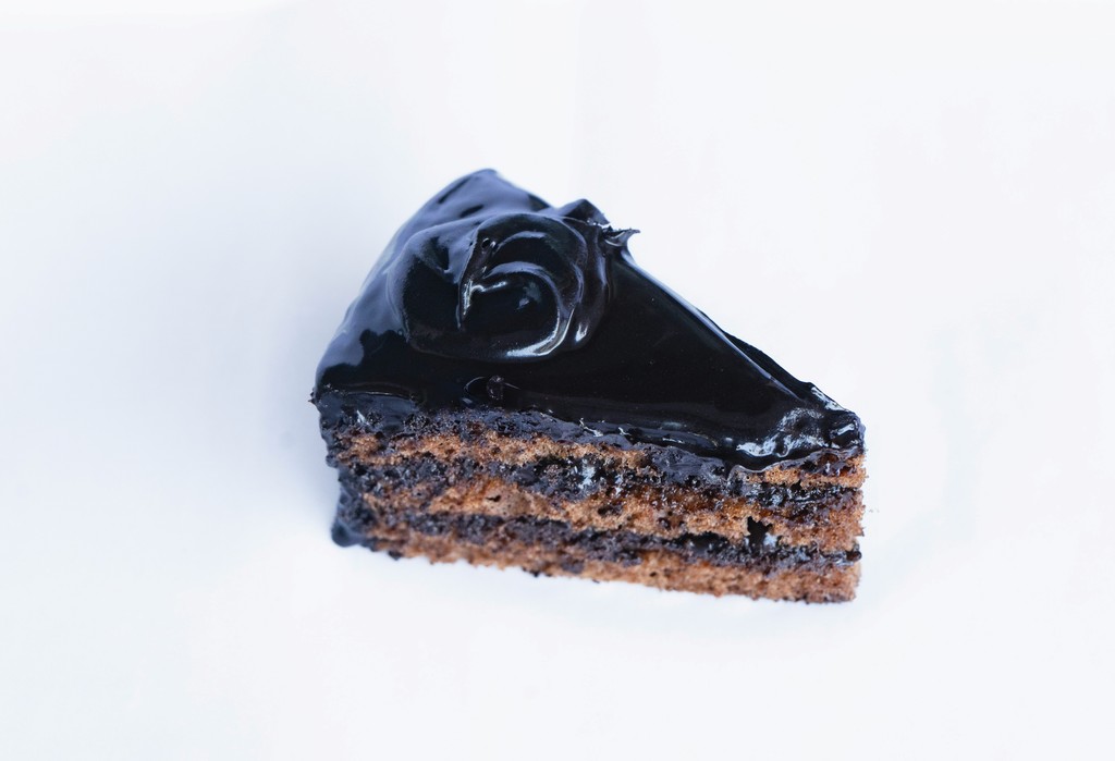 a piece of chocolate cake on a white surface