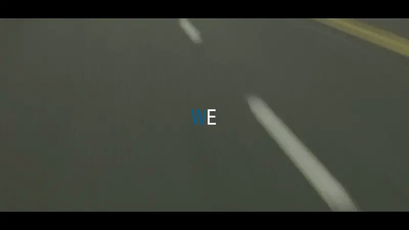 Stylised video frame showing a road surface with animated text overlay.