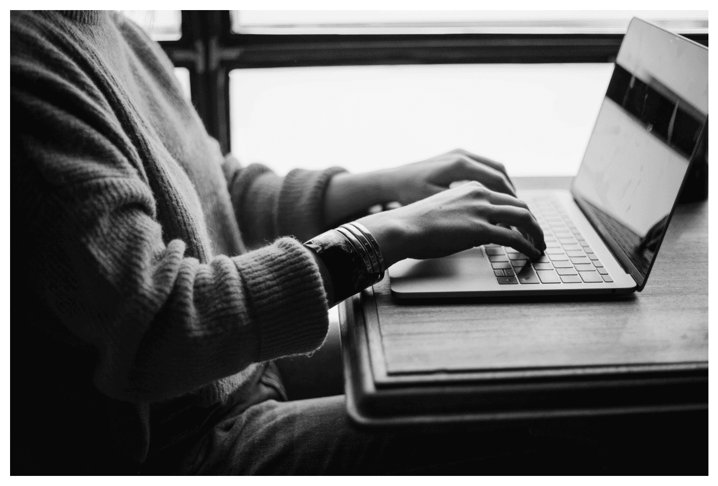 Person working on a laptop researching how automated ordering improves carrier and broker efficiency in transportation management.