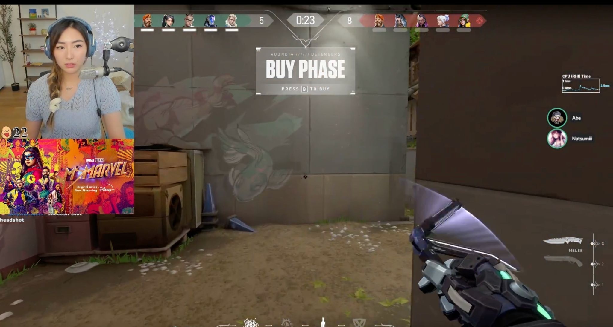 A streamer plays Valorant during the buy phase, with the Ms. Marvel overlay beside her camera